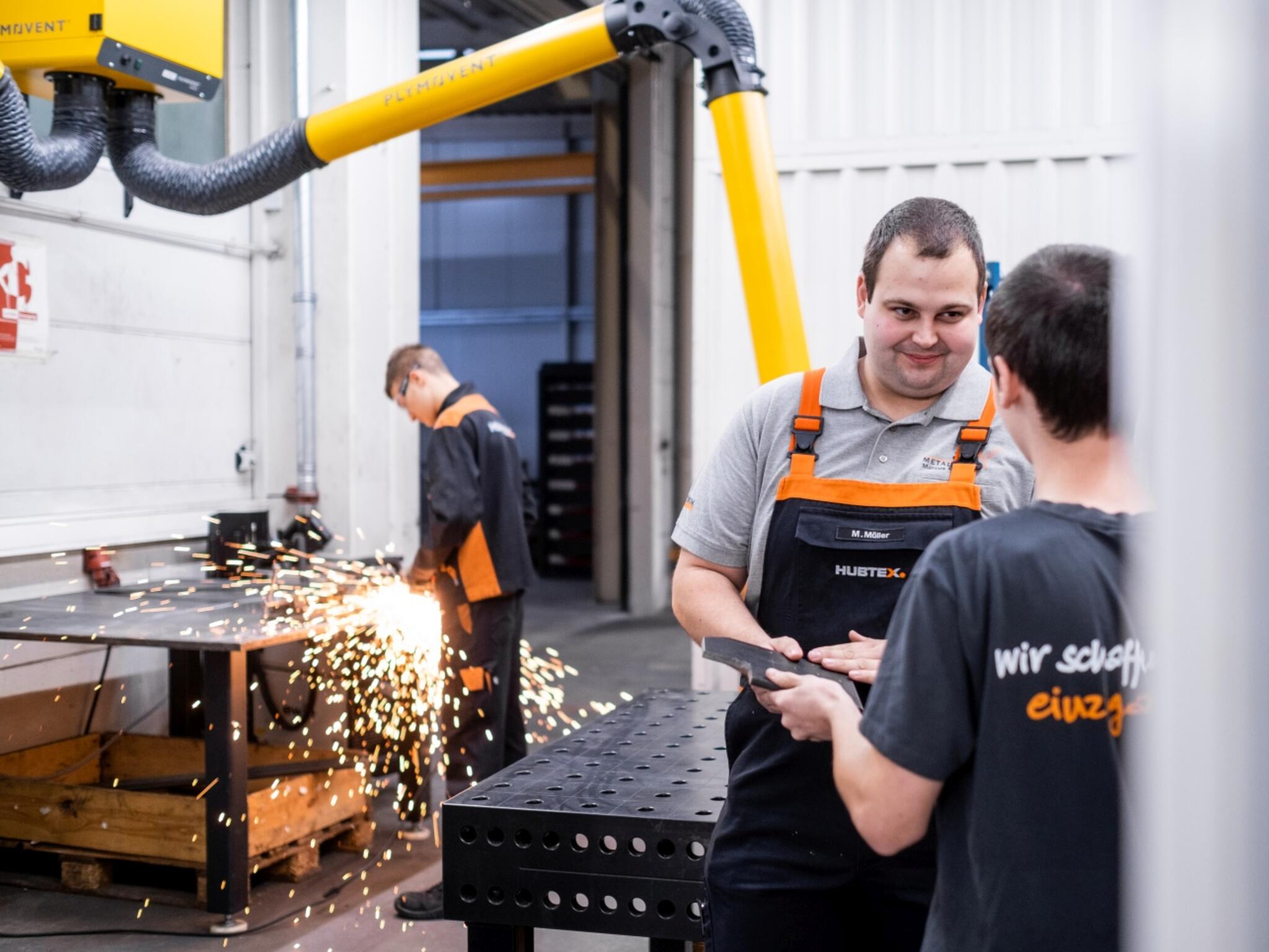 Ausbilder und Auszubildender Industriemechaniker in der Lehrwerkstatt
